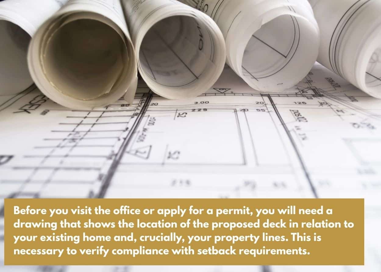 Rolled architectural blueprints laid out for deck construction planning and permit approval. Caption: Before you visit the office or apply for a permit, you will need a drawing that shows the location of the proposed deck in relation to your existing home and, crucially, your property lines. This is necessary to verify compliance with setback requirements.