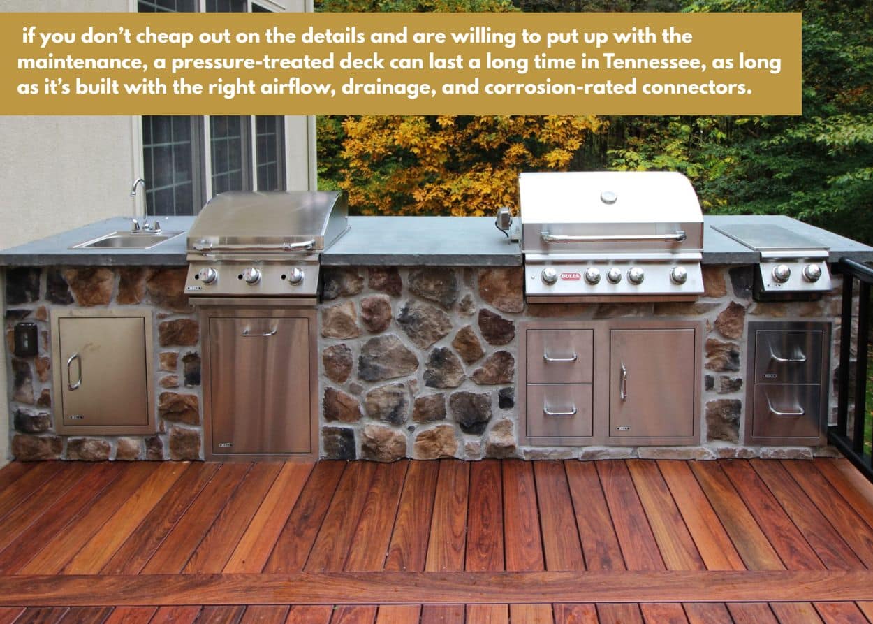 Stone outdoor kitchen on wood deck with built-in stainless steel grills and countertop sink