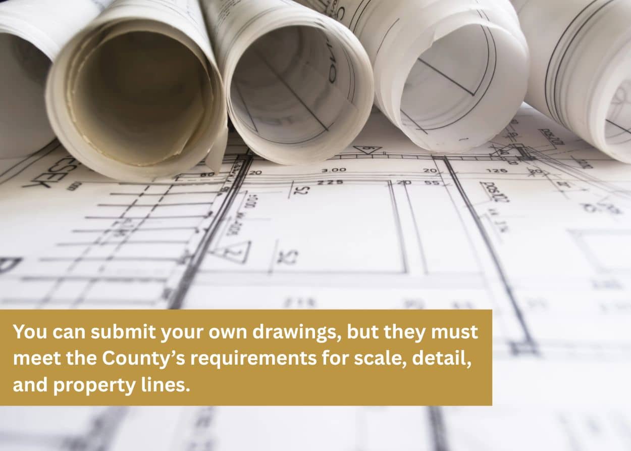 Rolled architectural blueprints laid out on top of detailed construction plans.