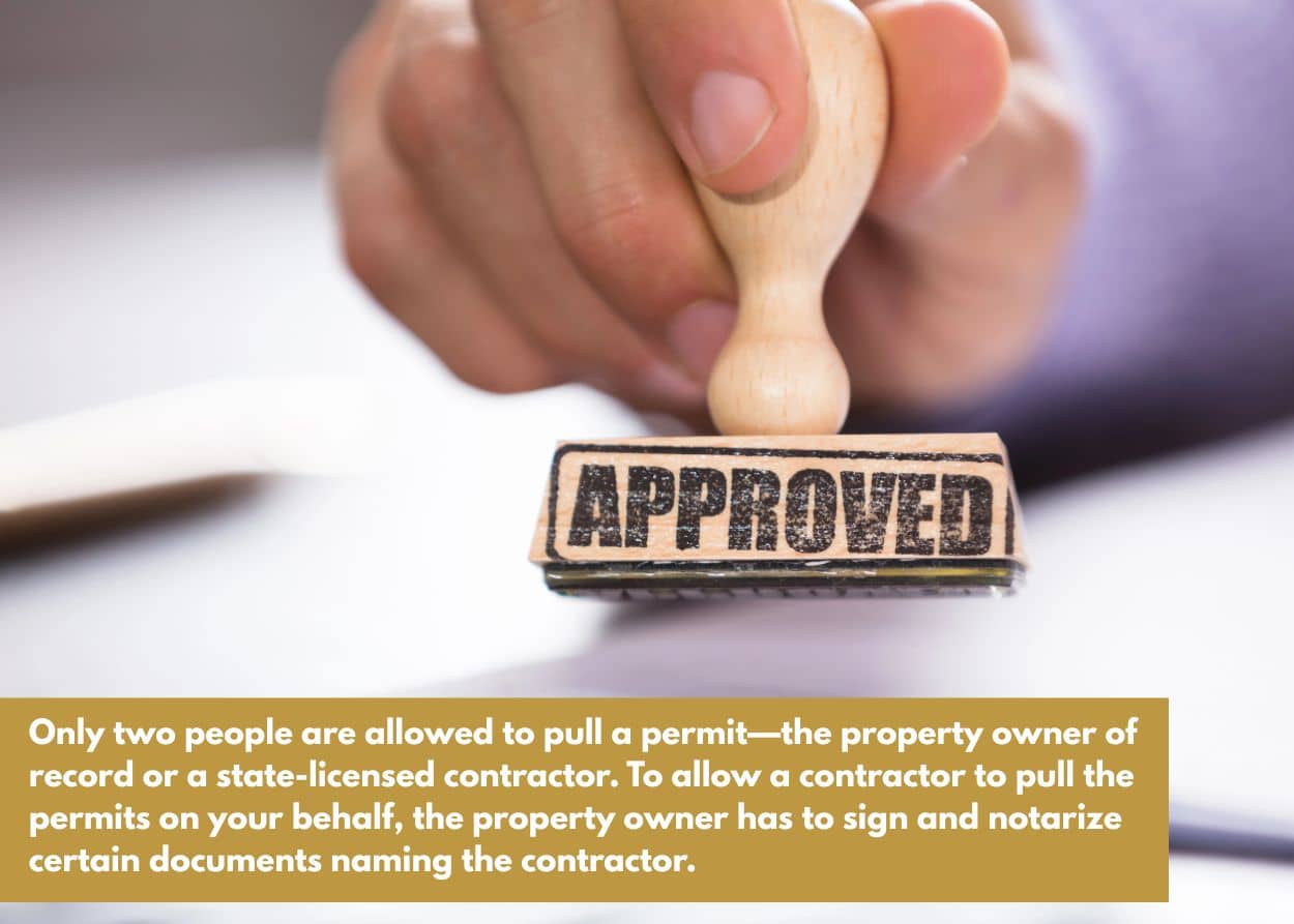Hand stamping approved permit paperwork, representing deck permit approval in Wilson County TN
