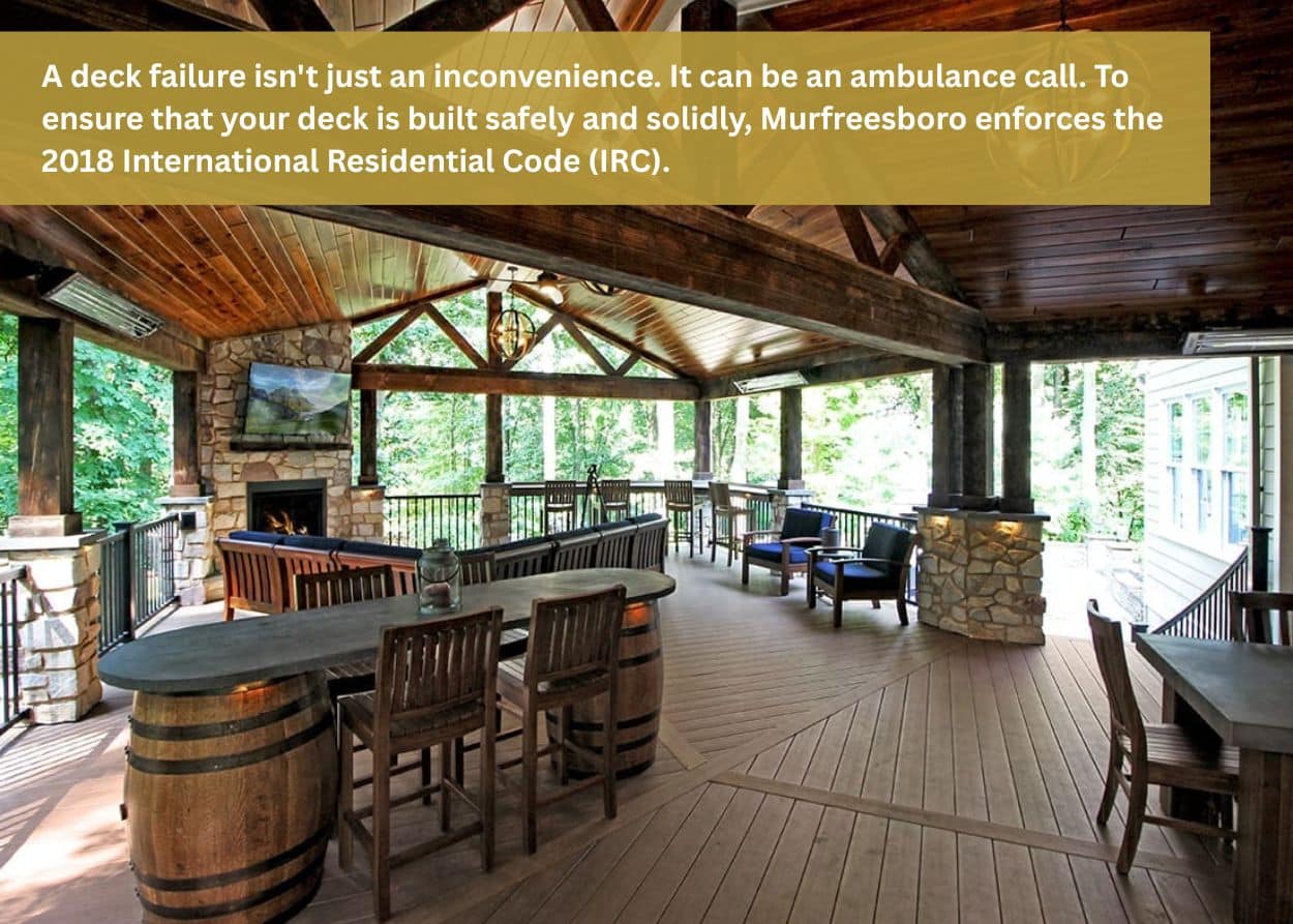 Covered outdoor living space with timber beams, stone fireplace, and composite decking built to meet local code requirements